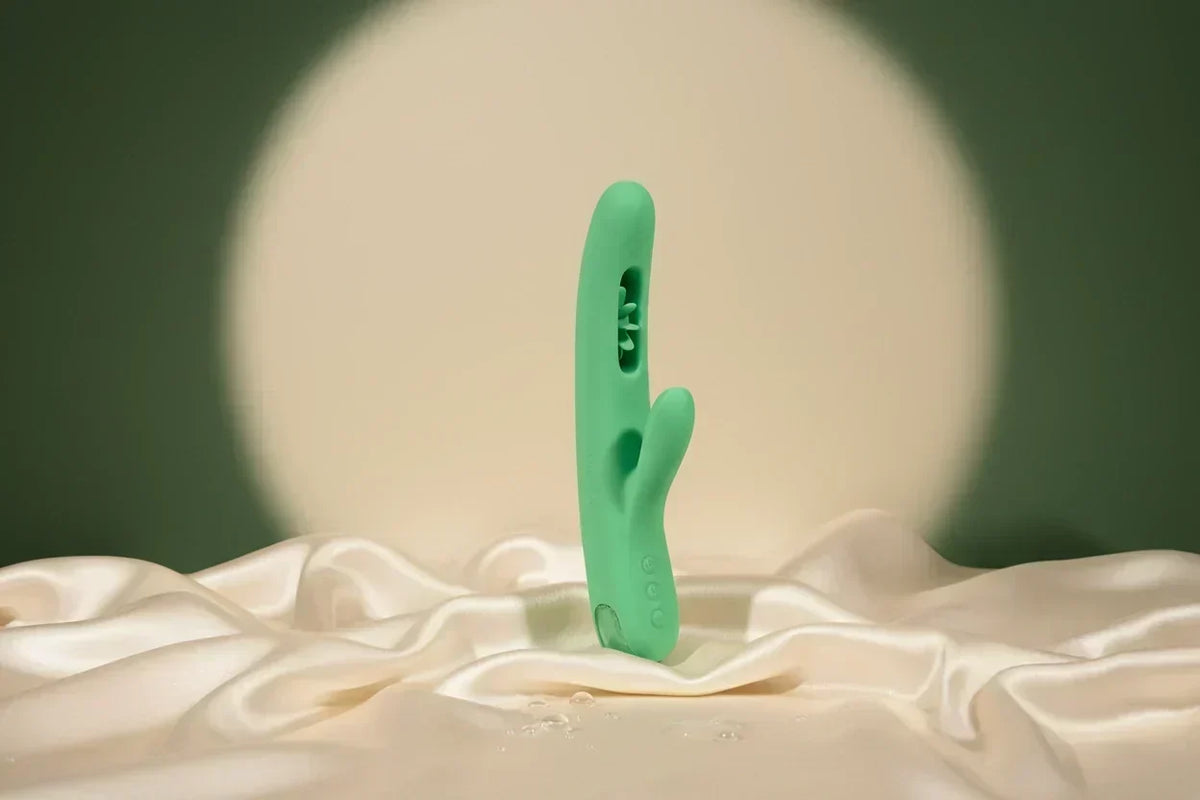 VINDANI Empower Green G-spot wellness device standing on draped ivory silk fabric